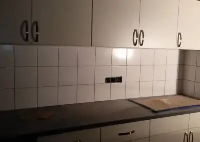 Tegelwerken in keuken met witte wandtegels en werkblad