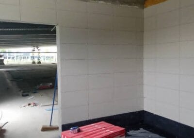 Renovatiewerken met geplaatste wandtegels en doorgang naar werkruimte