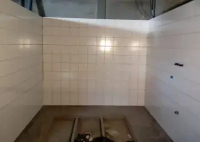 Binnenrenovatie met betegelde wanden en onafgewerkte vloer